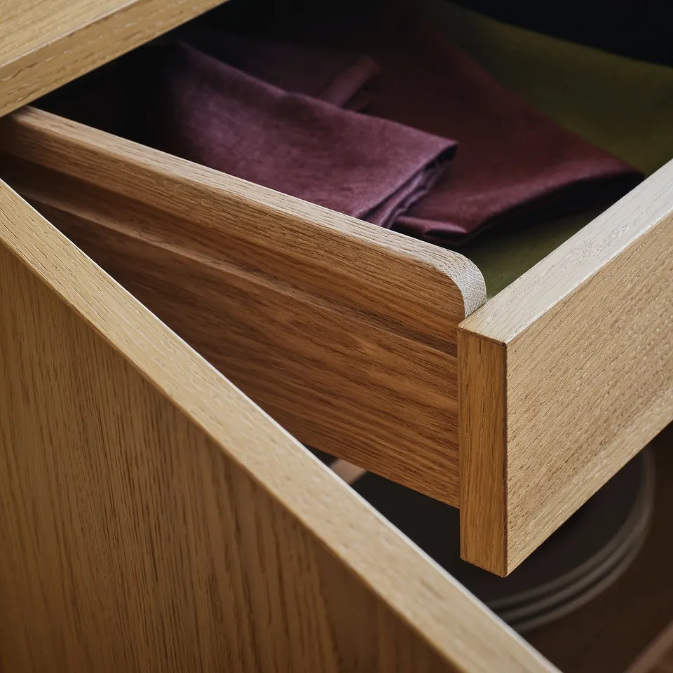 A close-up of open wooden drawers with sleek runners, showcasing craftsmanship.