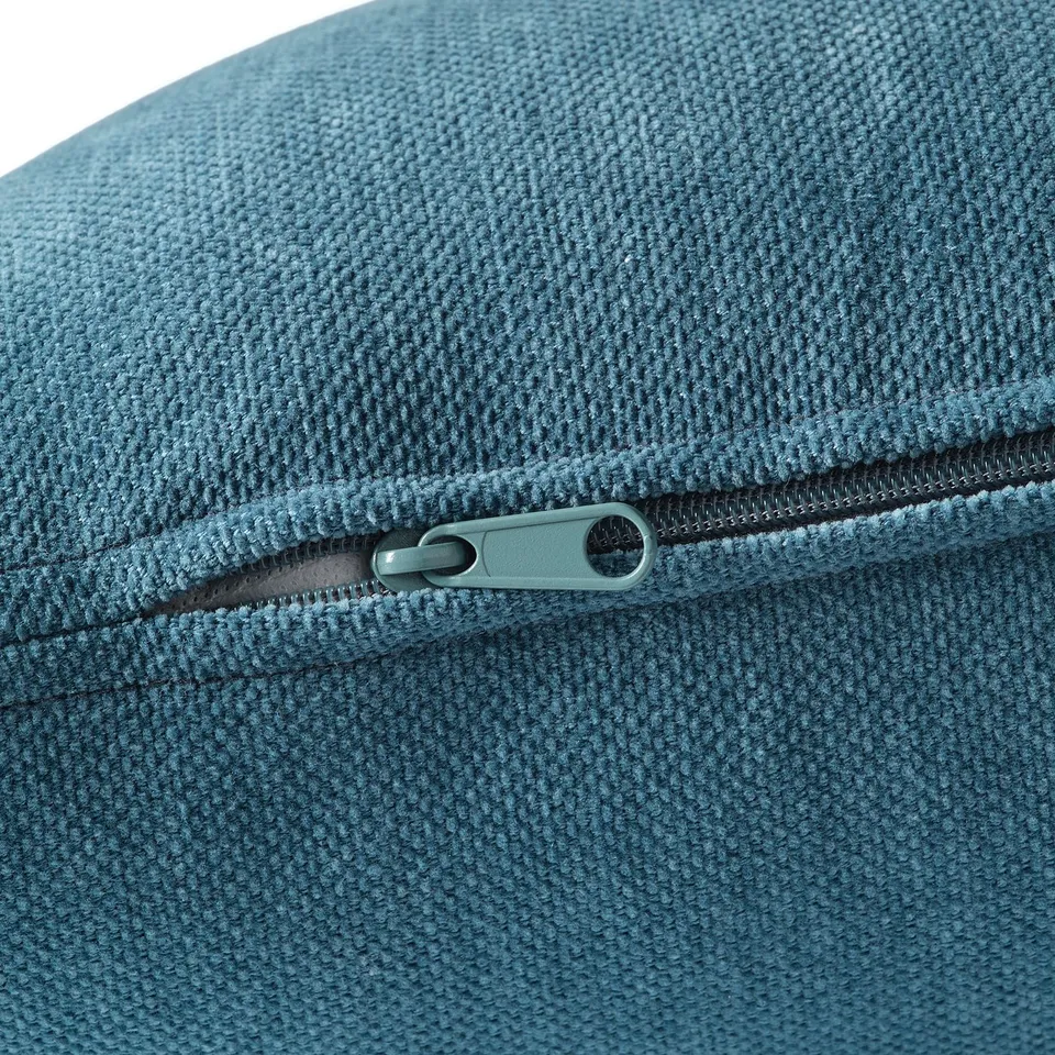 Close-up of a zip on a well-crafted, teal-colored upholstery, highlighting its quality and texture.