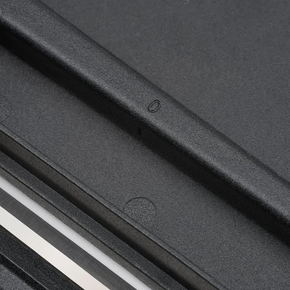 Close-up of black, sleek ikea chopping board, showcasing its smooth, sturdy surface and secure grip edges.