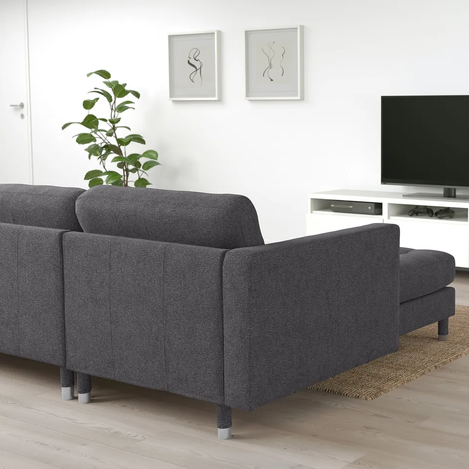 Modern dark grey fabric landaskrona sofa set with sectional, white wall, tv, art, plant.