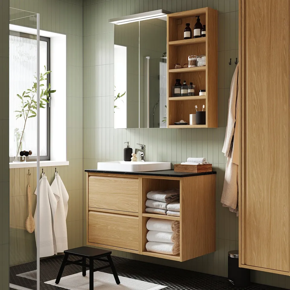 ÄNGSJÖN modern bathroom with oak cabinets, sink & mirror. Maximises space & adds warmth.