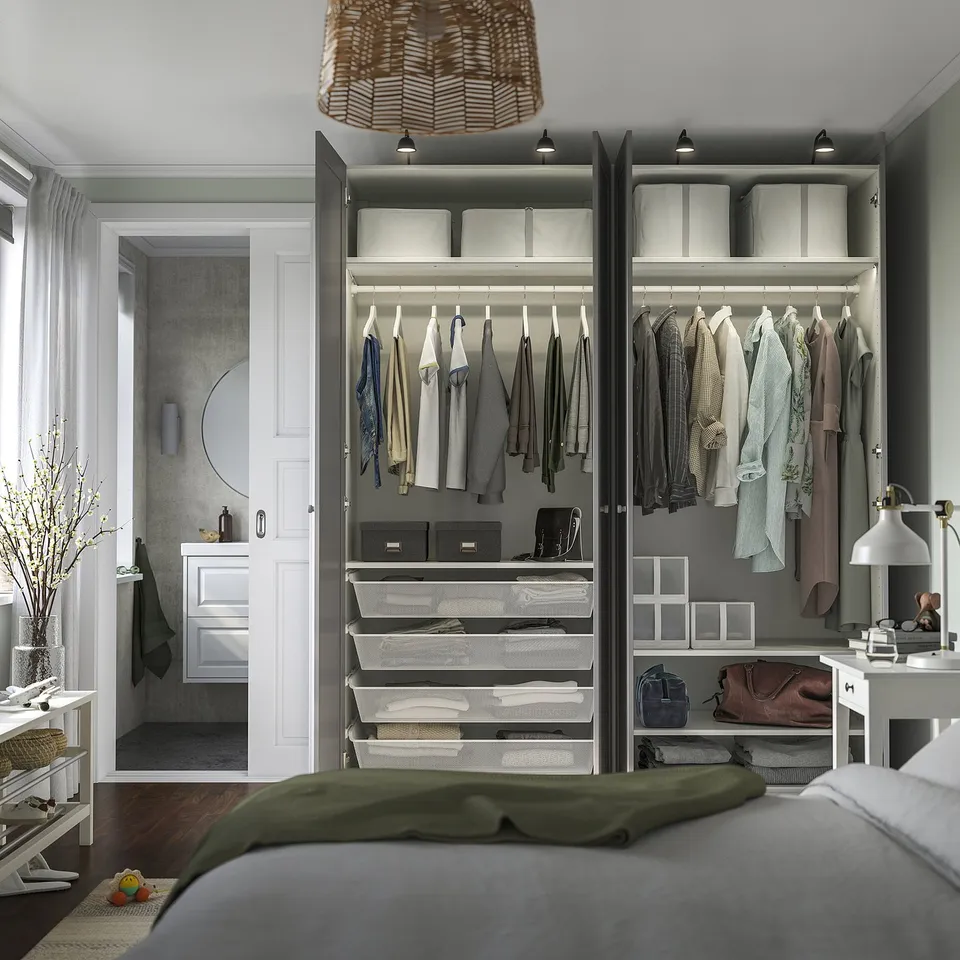 Modern bedroom with built-in wardrobe PAX showing organised clothes, shelves, and lights.