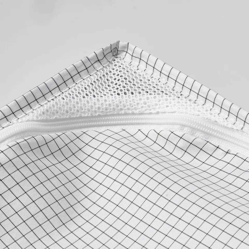Close-up of mesh zip bag, showcasing durable, breathable fabric with diamond patterns, ideal for storing clothes.