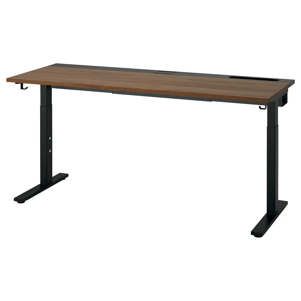 The MITTZON desk a rectangular wooden top with a brown finish and black metal legs, designed for height adjustment and cable management.