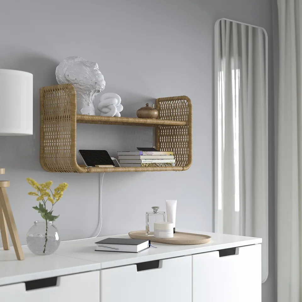 Wall-mounted wicker shelf holds towels, books, and phone. Rubber chargers through wall gap.