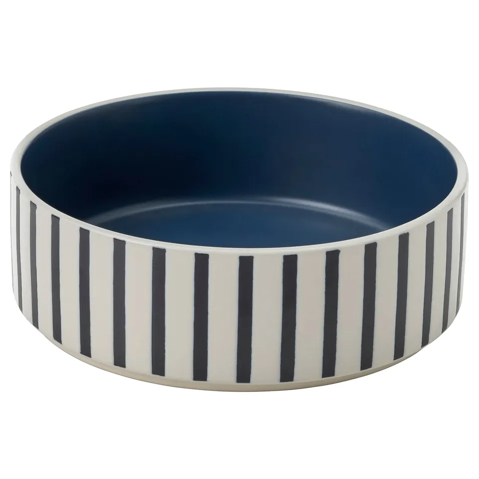 The UTSÅDD pet bowl is blue inside, white with black stripes outside, made of stoneware, and designed for durability and modern decor.