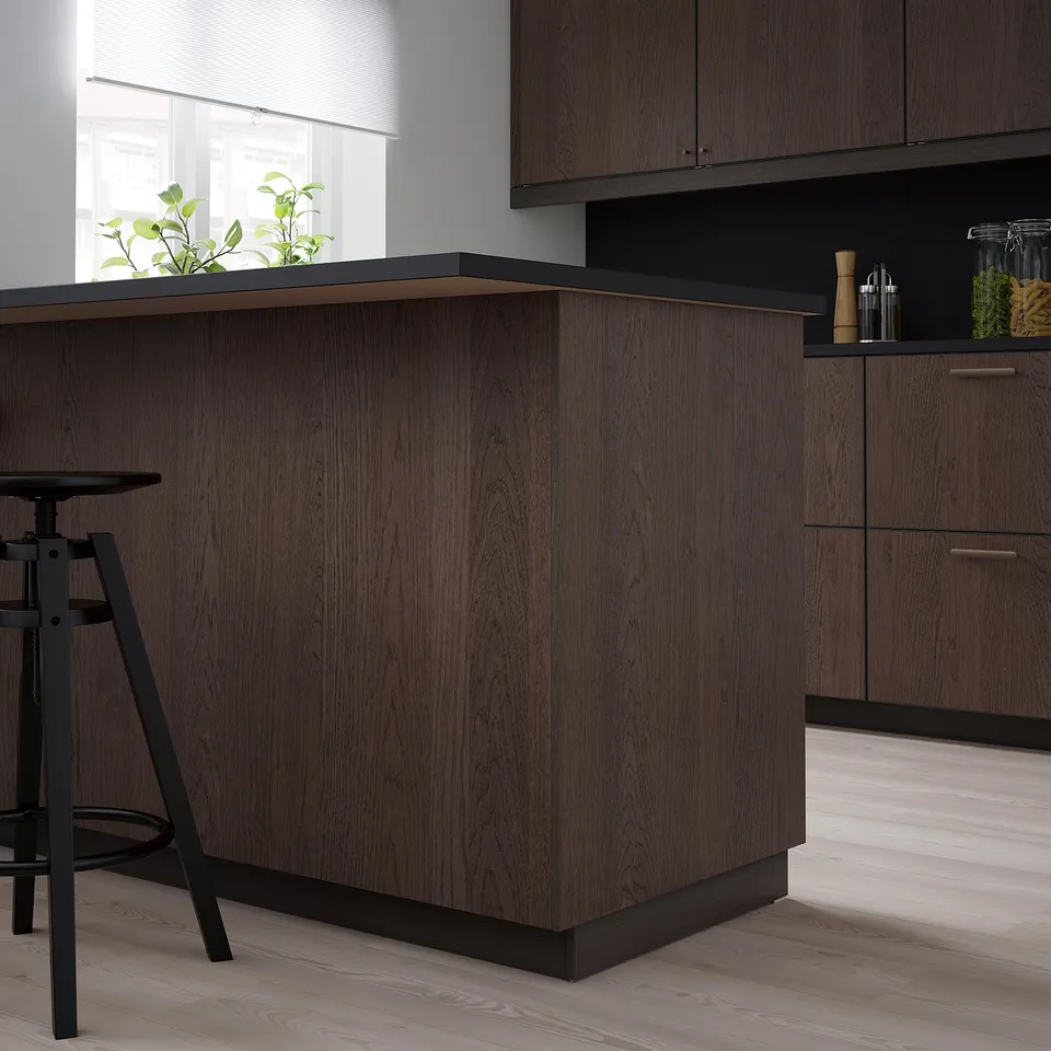 Modern dark wood SINARP kitchen cabinets with sleek design. Base units and tall cabinets complement light wood floors. Stool included.