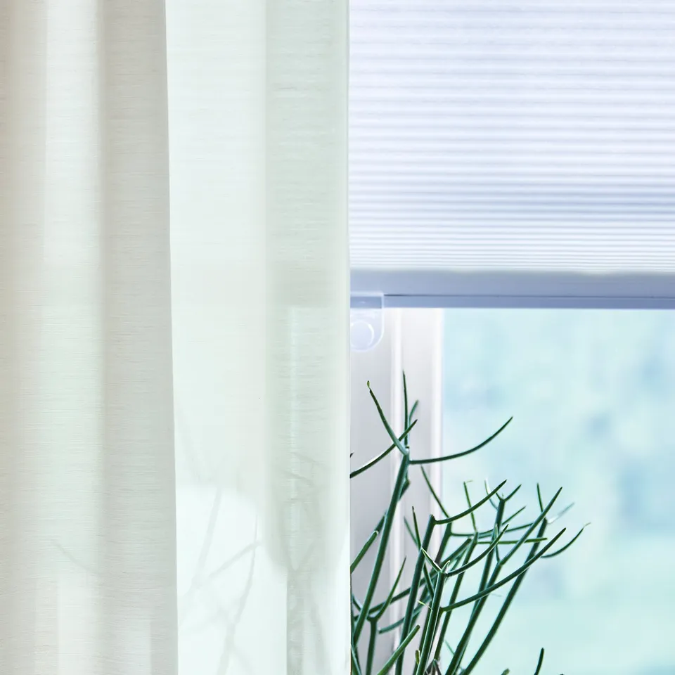 Modern white window blind with soft light filtering fabric, sleek design for privacy and sun protection.