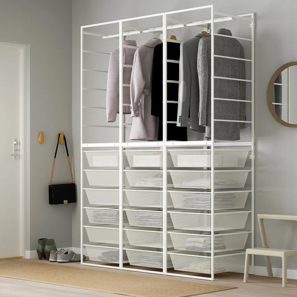 White JONAXEL wardrobe with clothes, shelves, chair, minimalist design.