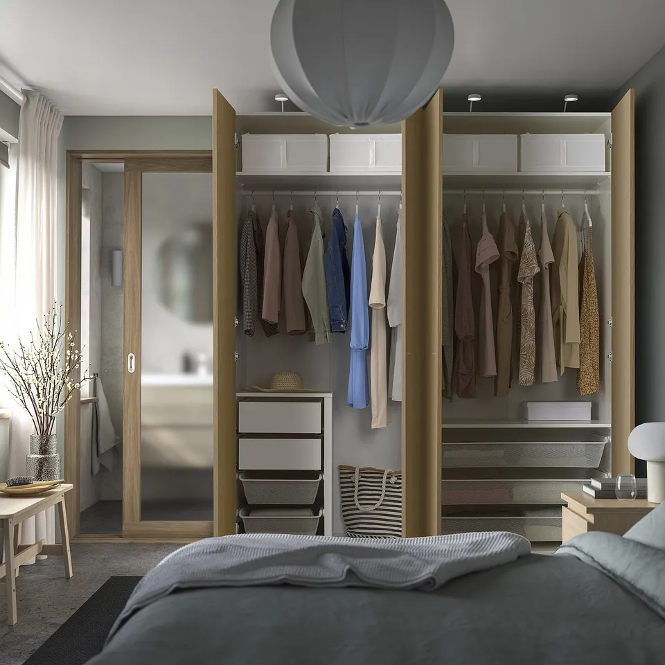 Bedroom with open wardrobe showcasing clothes, shelves, and storage boxes.