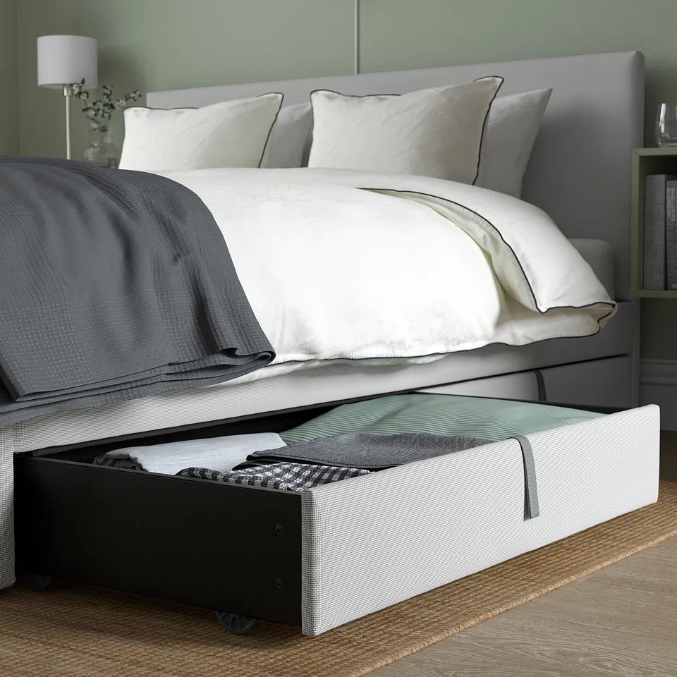 Modern bed with grey upholstery, storage boxes, and padded headboard