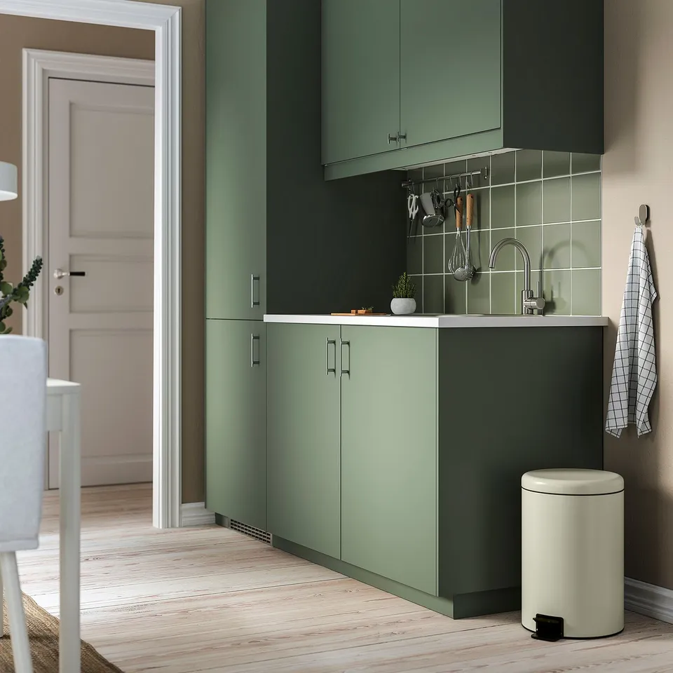 Modern kitchen with green STJÄRNHOV handles. Chrome, sleek, and minimalist design. Smaller than drawers, fits neatly.