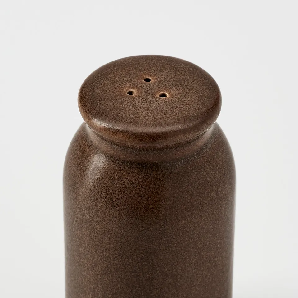 BRUGDHAJ spice dispenser, rustic stoneware, glossy finish, textured surface, round top with holes for controlled spice flow.