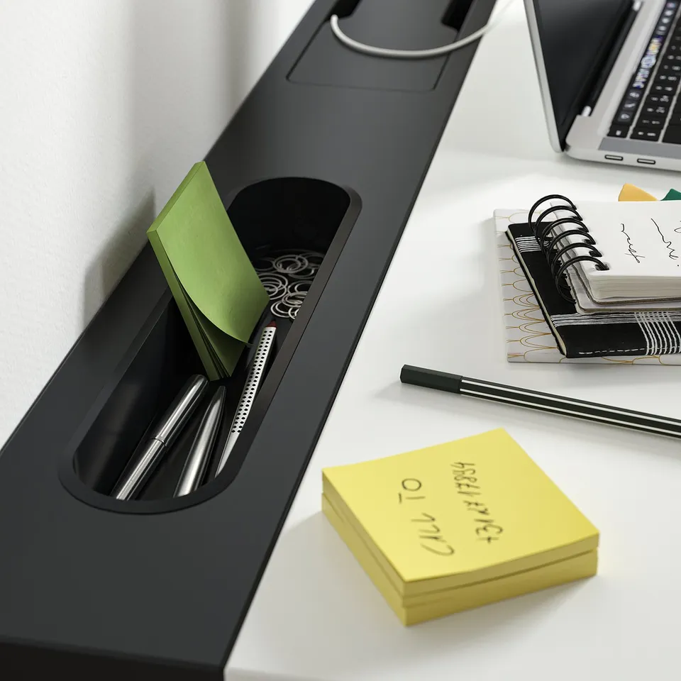 Modern office desk with built-in compartments for pens, papers, and a laptop.