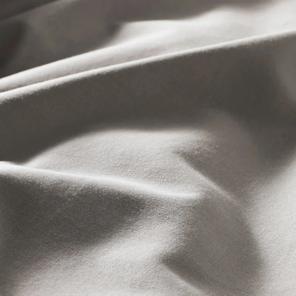 Soft, light grey duvet fabric close-up, smooth texture visible.