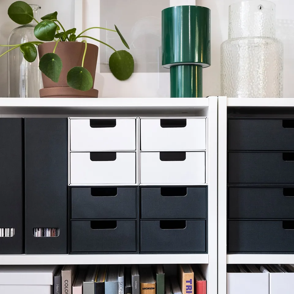White FJÄDERHARV mini chest with six small drawers on a bookshelf, perfect for small items. Made from recycled paperboard.