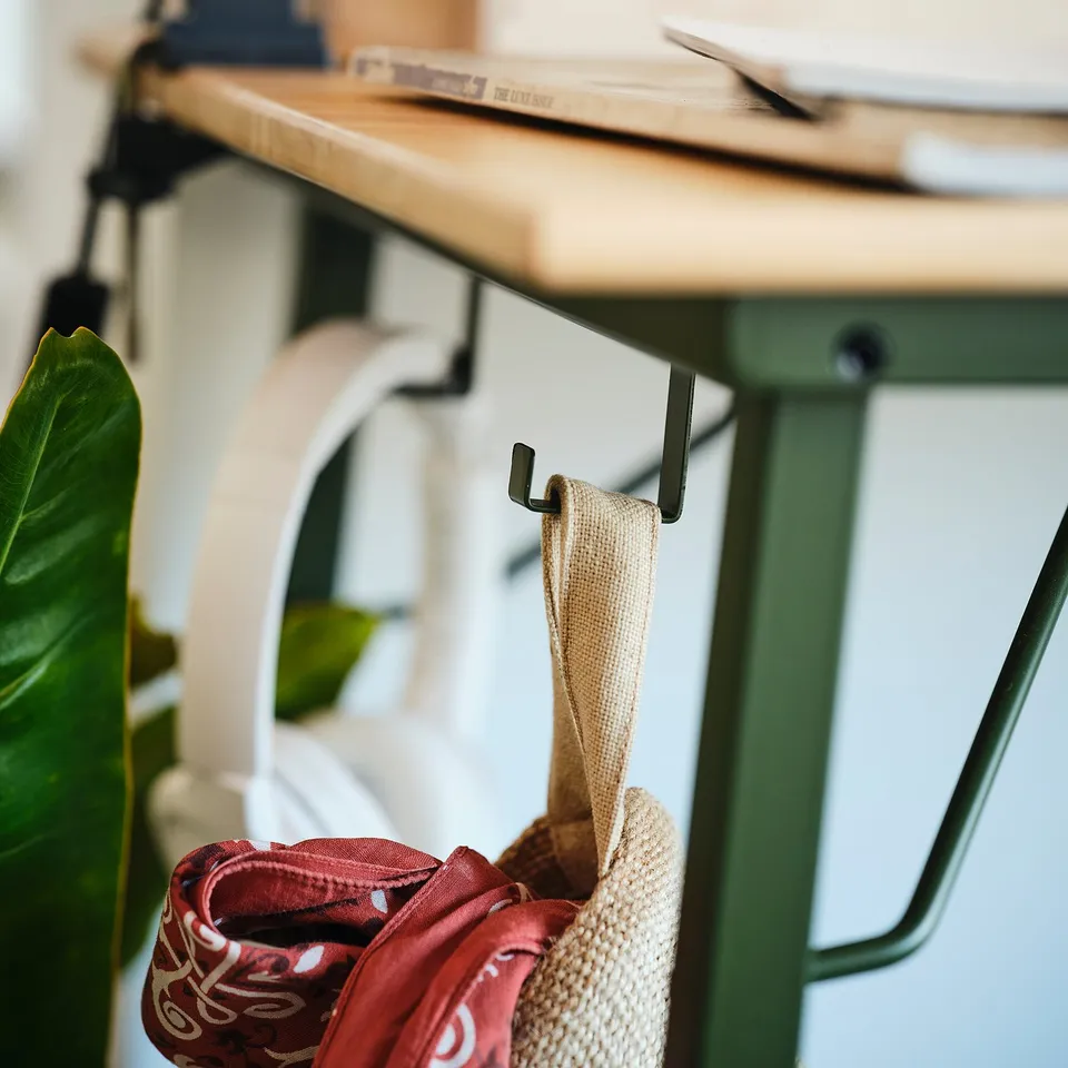 Table with durable eucalyptus top and sturdy hooks. Clothes hanging on side, demonstrating quality and space-saving design.