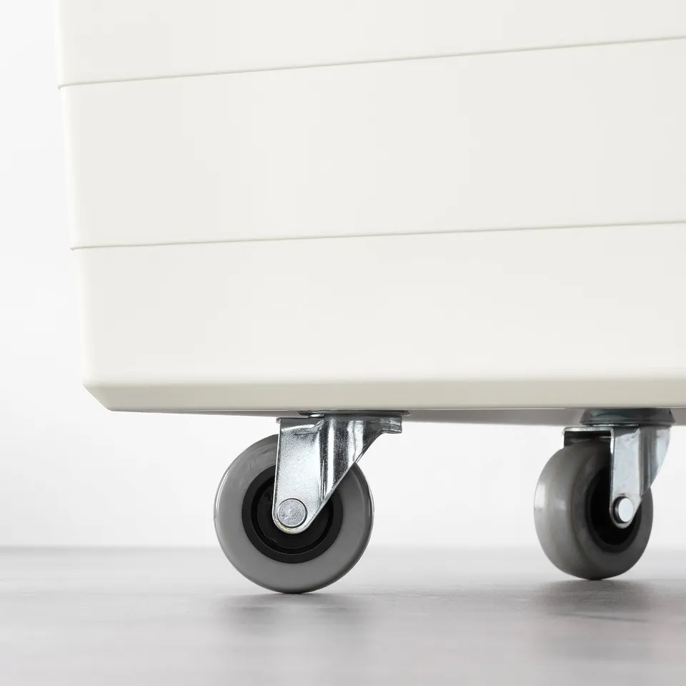 Close-up of two swivel castors under a white box, showing how its designed to easily move heavy items.