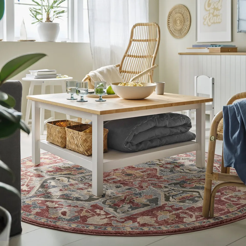 Cosy living room with wooden coffee table, snacks, and plant.