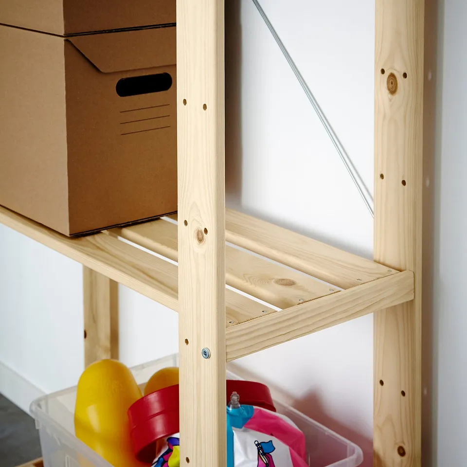 Wooden storage unit holds cardboard box and plastic bins with childrens toys.