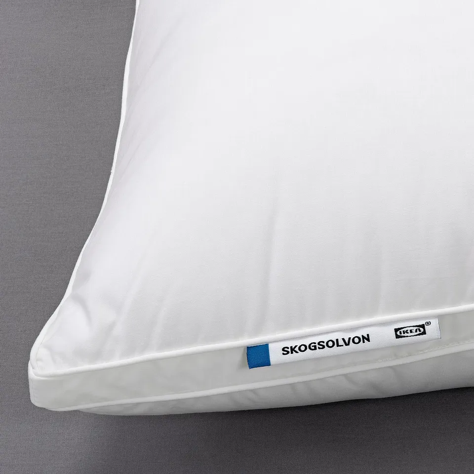 White SKOGSOLVON pillow on bed, soft, breathable, and supportive for comfort.