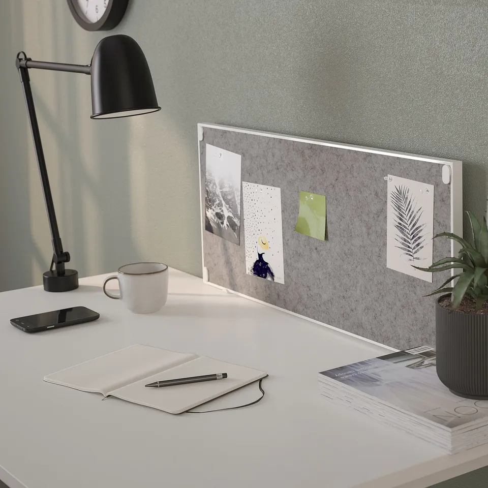A TROTTEN desk pinboard combo with lamp, mug, and notebook.