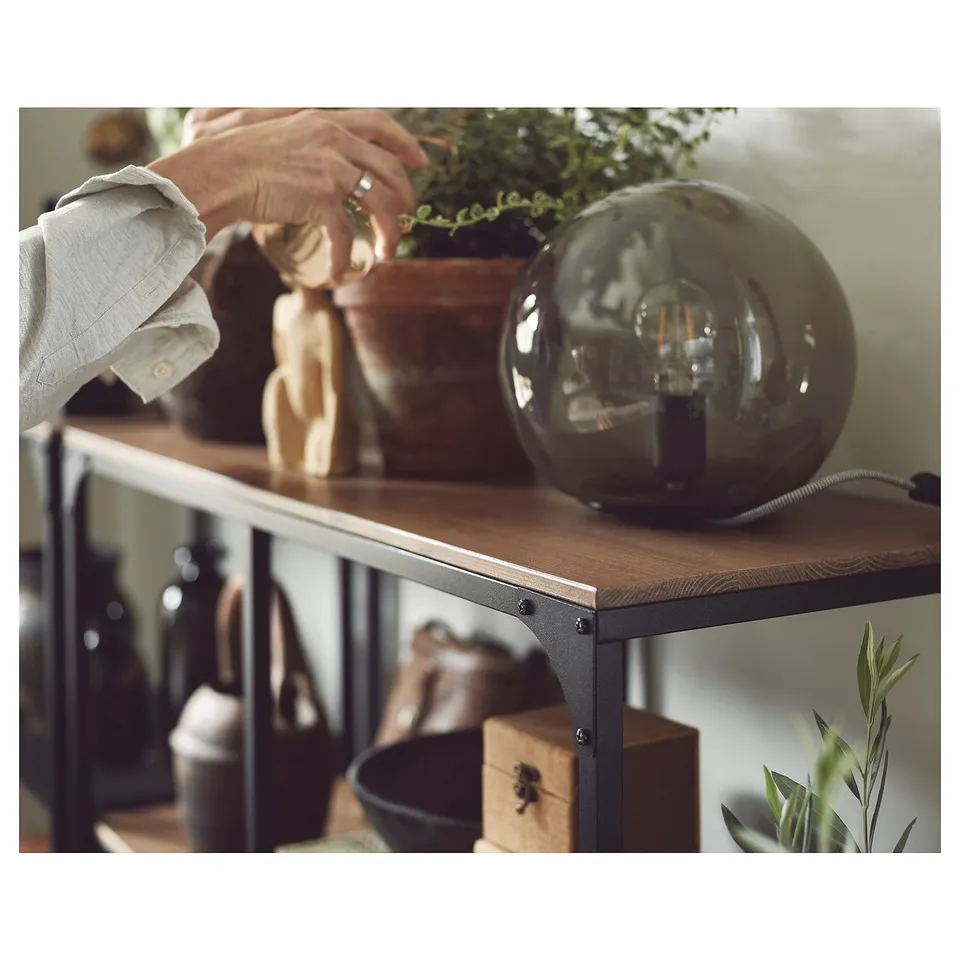 Image shows a wooden & metal FJÄLLBO shelf with a smoky light bulb, plants, and decorative items.