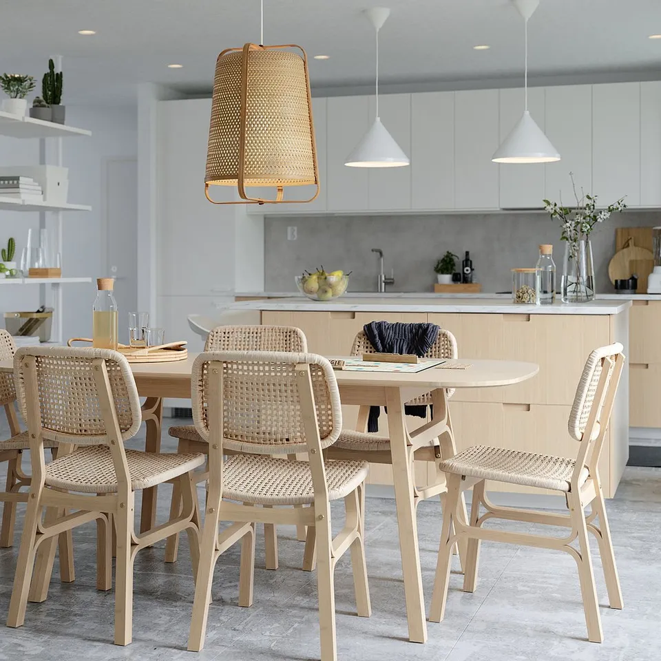 Modern dining room with VOXLÖV bamboo chairs, white pendant lights, sleek kitchen island, and decorative shelving.