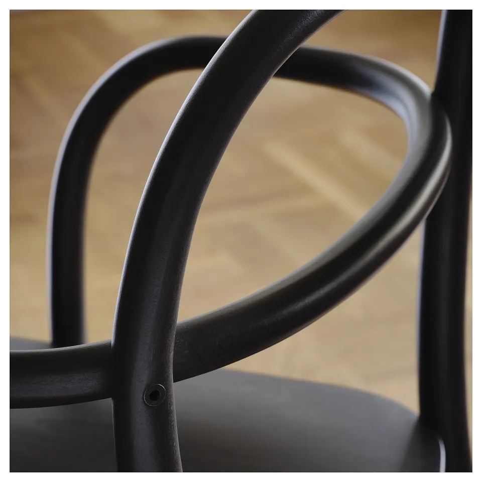 Close-up of elegant, black, curved chair frame, showcasing smooth, durable design.