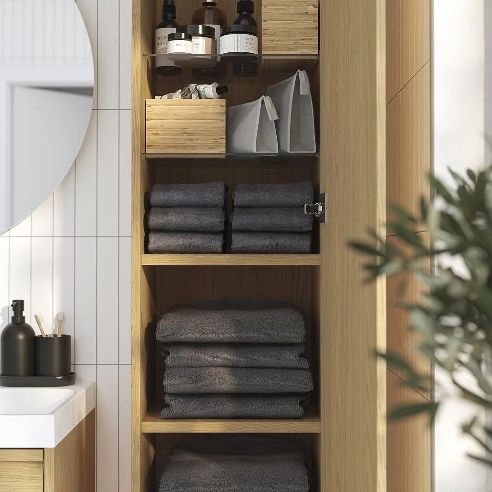 Bathroom cabinet with shelves storing folded towels, toiletries, and organisers. Minimalist design with integrated handles.