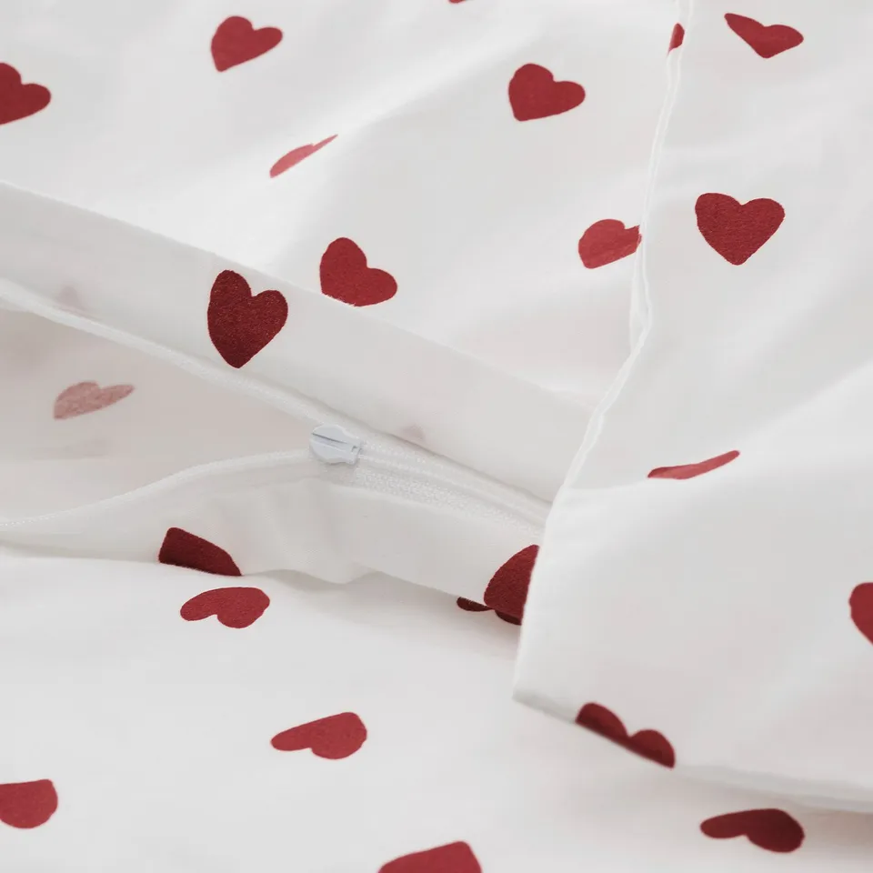 White baby duvet cover with red heart patterns and a zip.