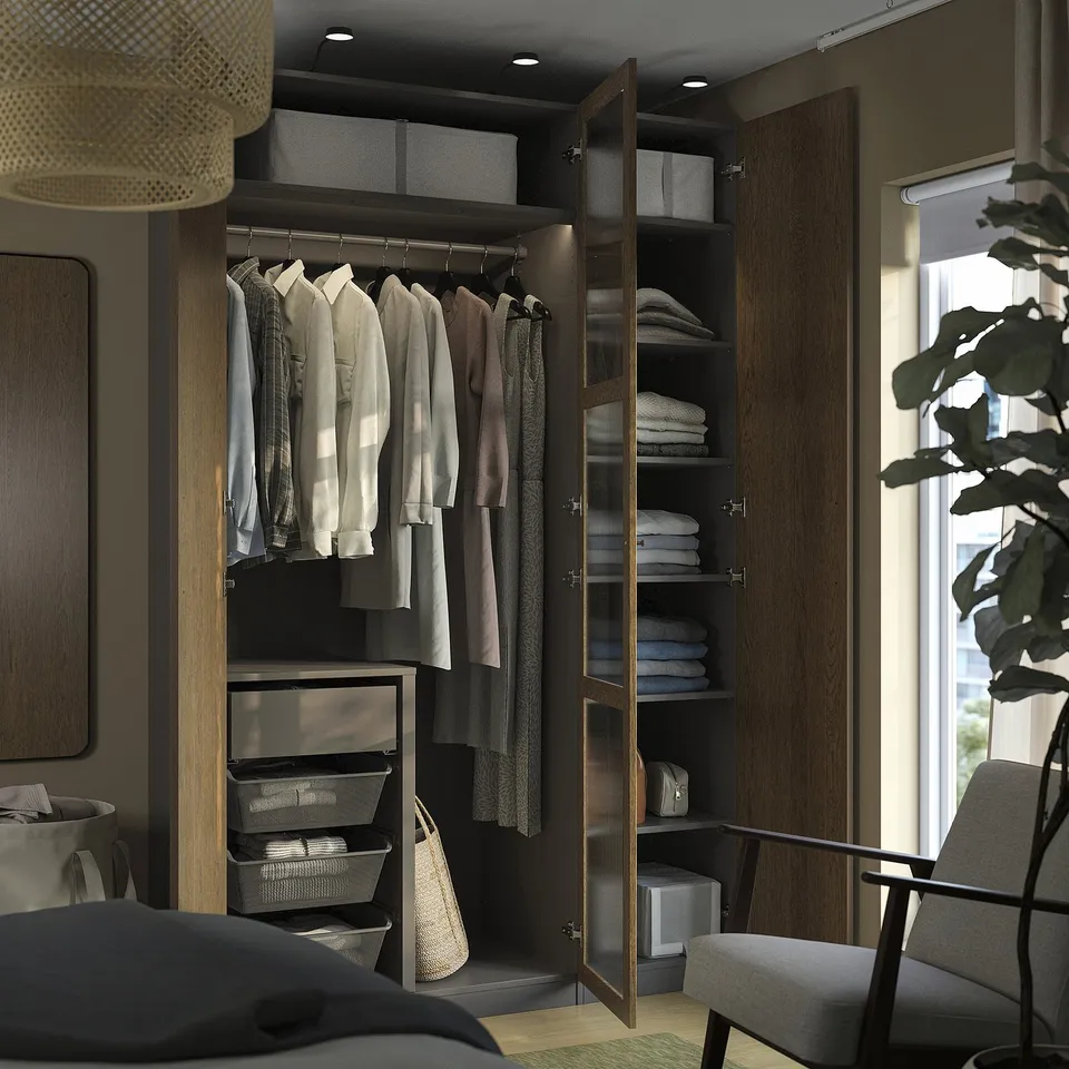Modern closet with shirts and folded clothes. Includes drawers, baskets, and hanging space. Integrated lighting highlights the organised interior.