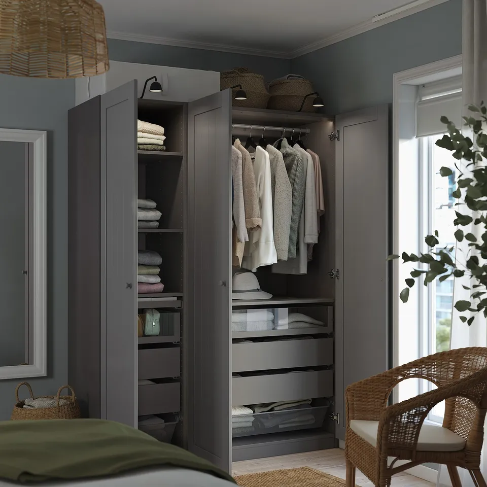 A well-organized bedroom wardrobe with clothes, towels, and drawers. Lighting and shelves are visible inside.