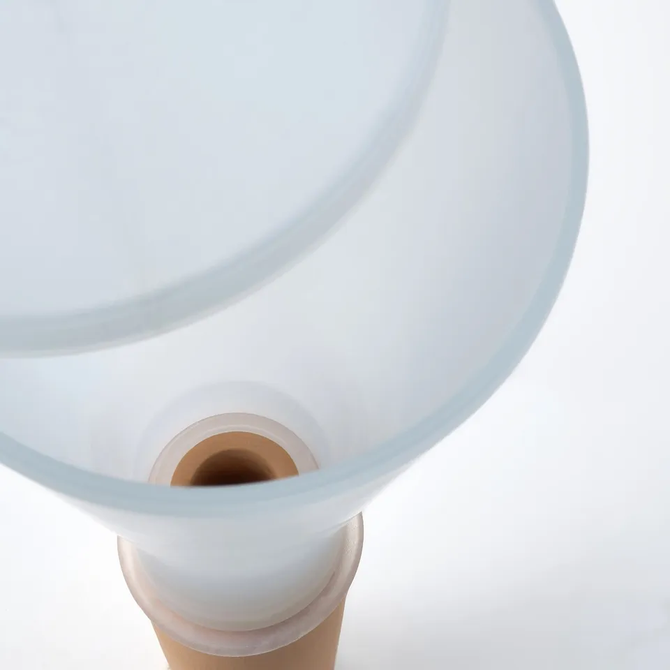 Modern clear watering device, terracotta insert, semi-transparent plastic container, sleek design.