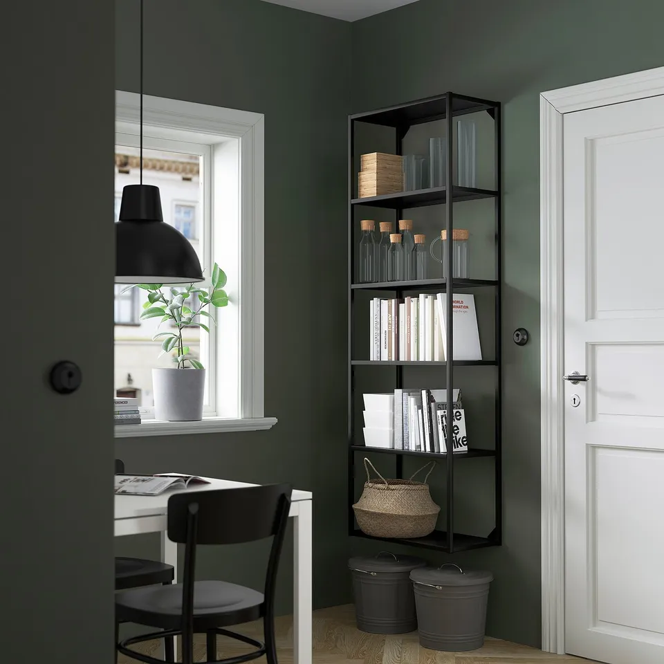 Black ENHET shelf with items, green wall.