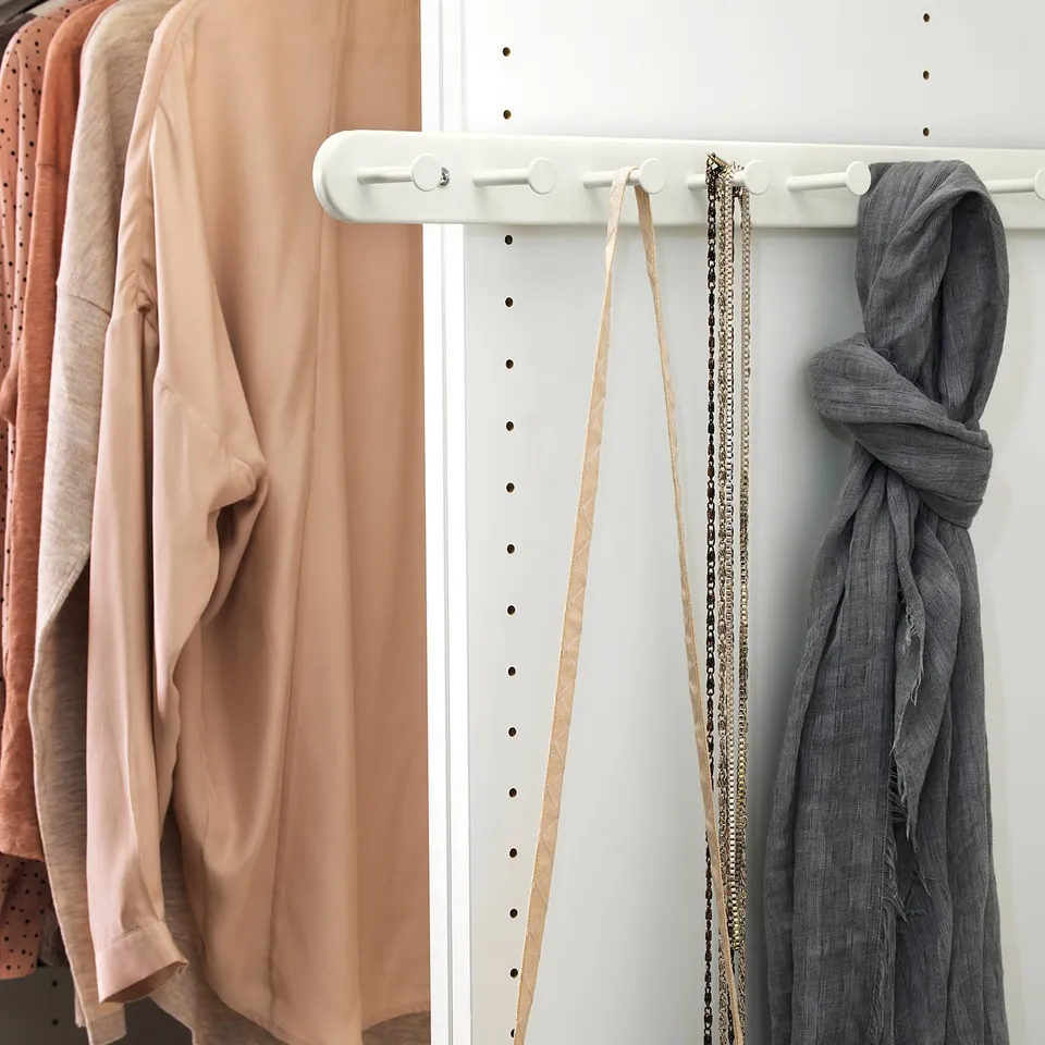 White KOMPLEMENT closet with clothes and accessories.
