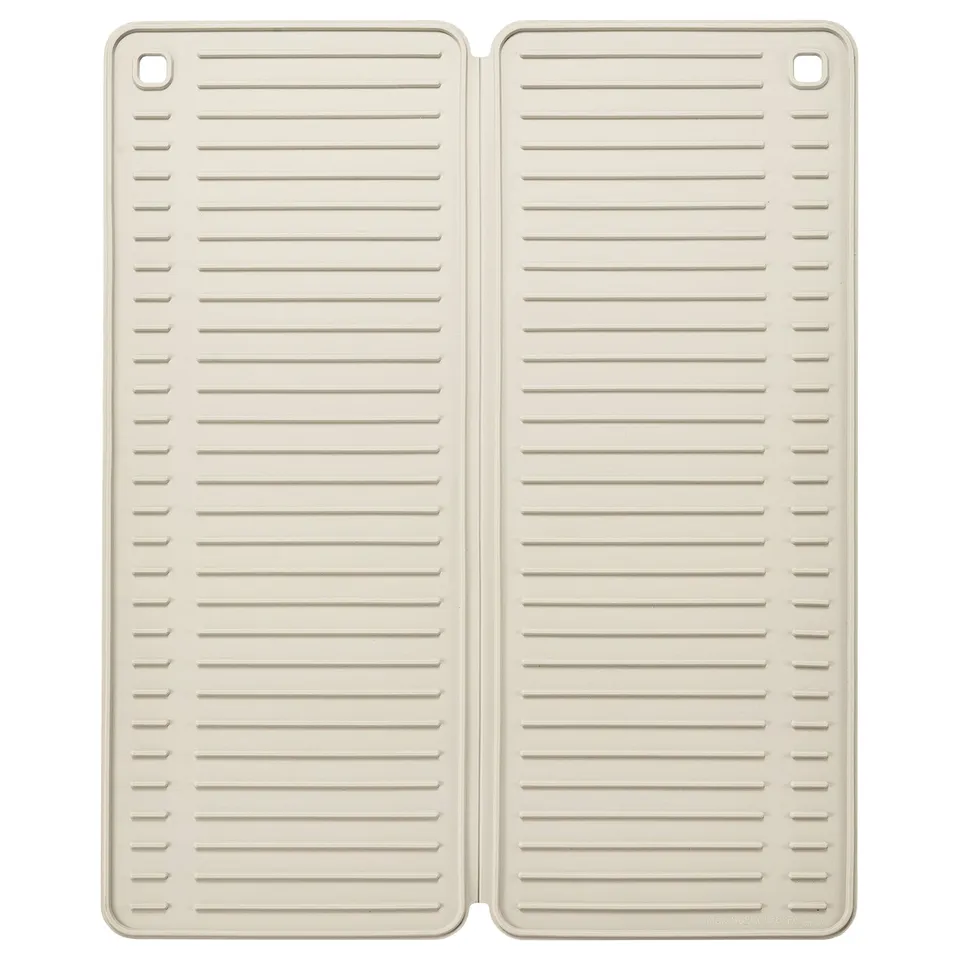 Two beige silicone mats with horizontal lines and rounded corners, folded and placed side by side.