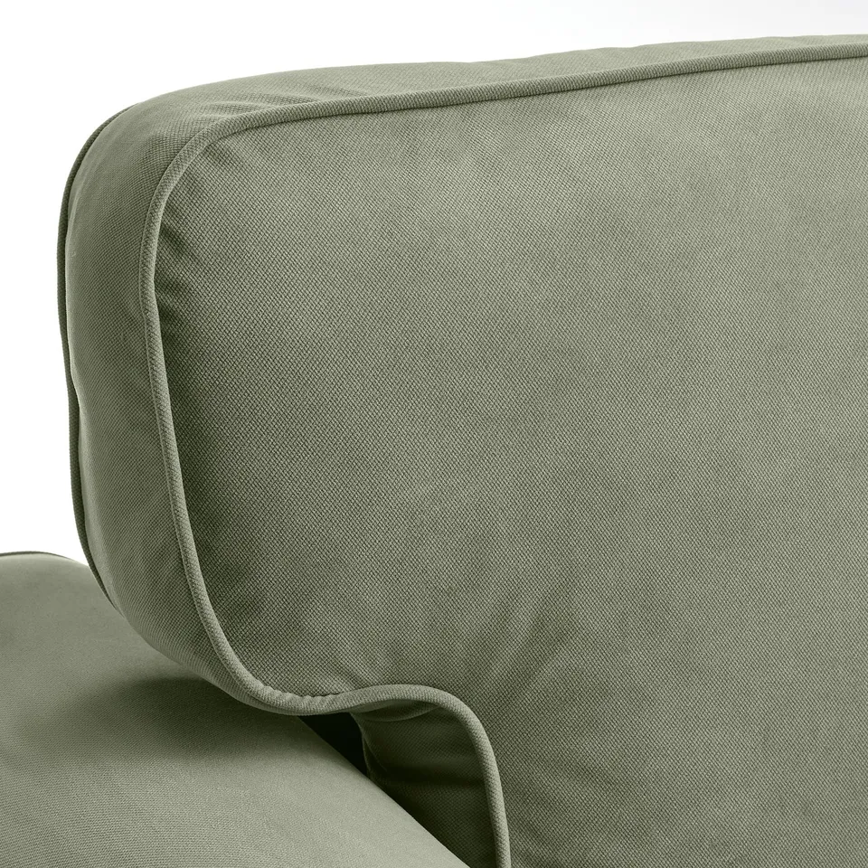 Close-up of cushioned armrest on VRETSTORP sofa, showcasing soft green fabric and neat stitching.