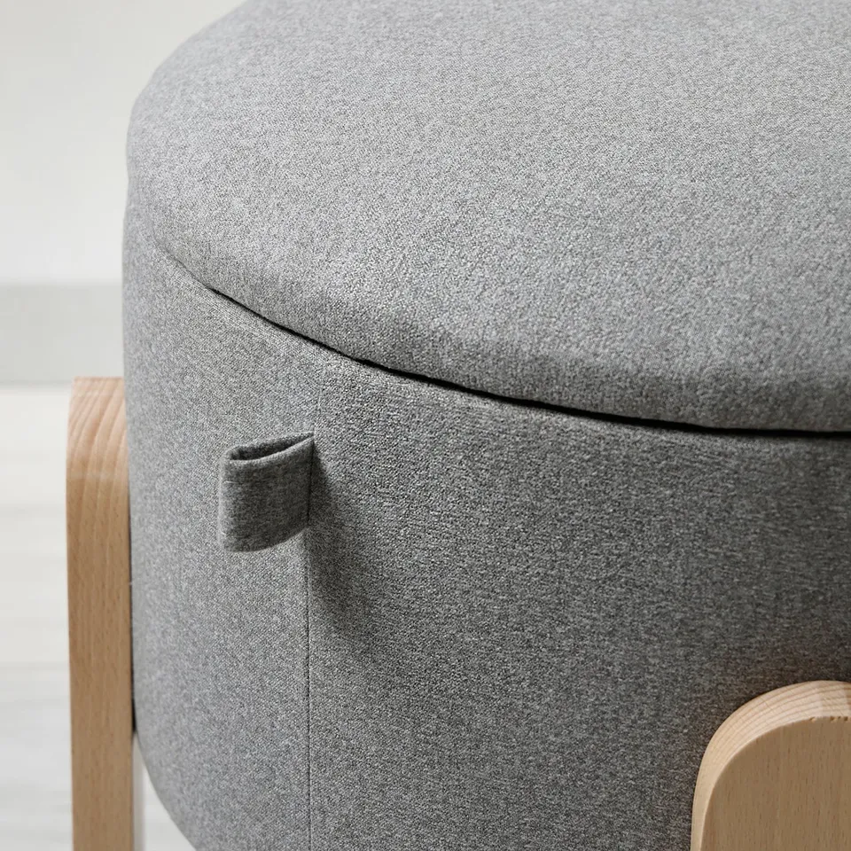 Close-up of FÖRLUNDA pouffes upholstered, grey, soft fabric cover with wood base; showcasing fine craftsmanship.