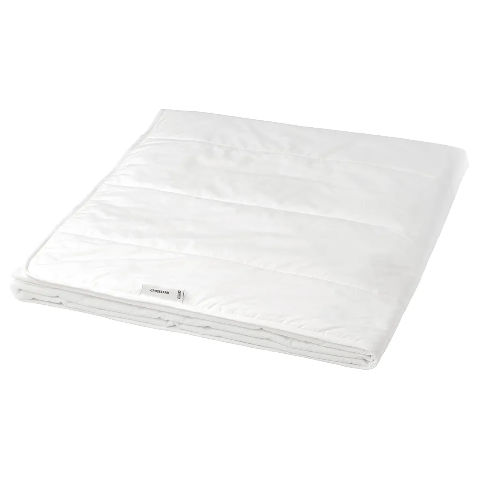 A white GRUSSTARR duvet with printed dots, made of lyocell and cotton, filled with polyester and viscose, neatly folded.