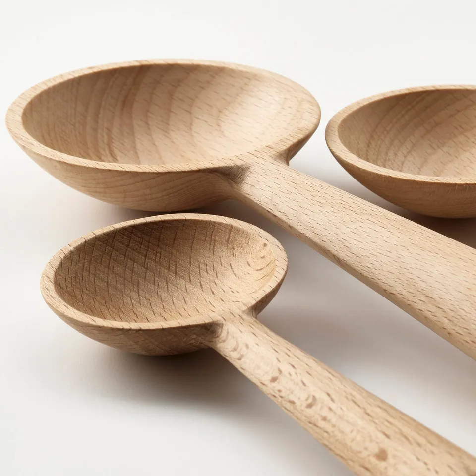 Three beechwood spoons, polished, in a triangle.