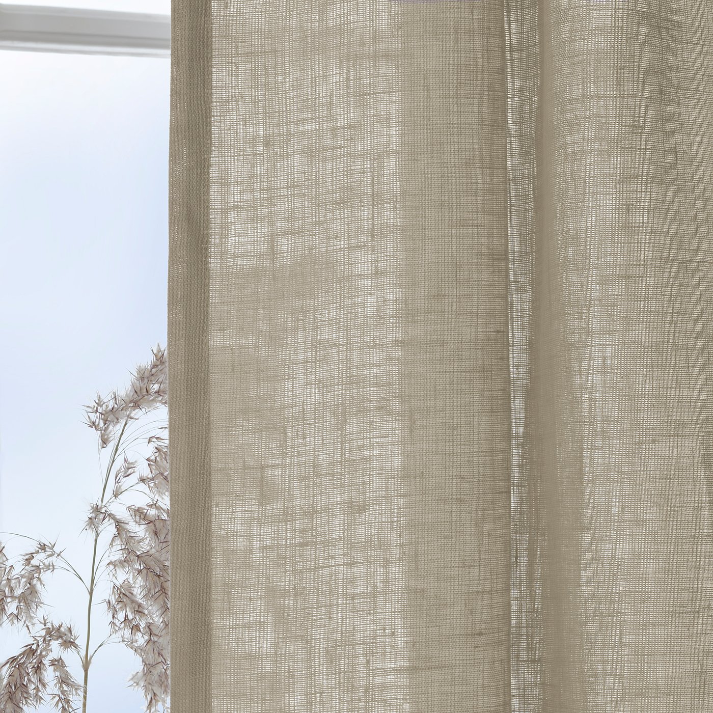Beige linen curtains hanging, providing light filtration and privacy. The curtains have multi header tape for rod or rail installation.
