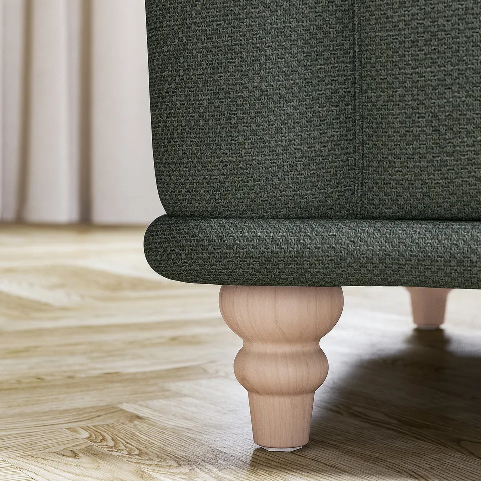 Dark green textured sofa with turned wood legs on wooden floor.