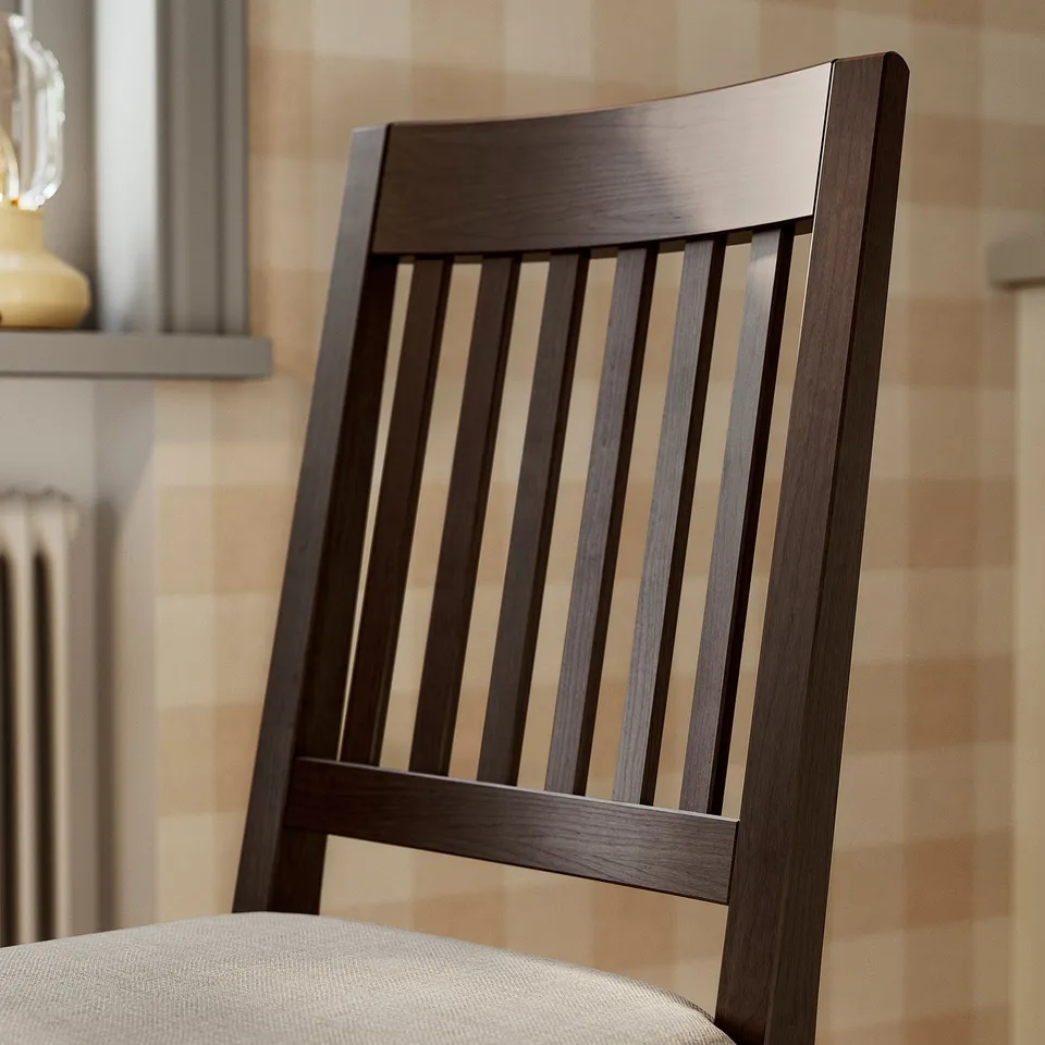 Dark wood chair with vertical slats, upholstered seat, set against patterned wall.