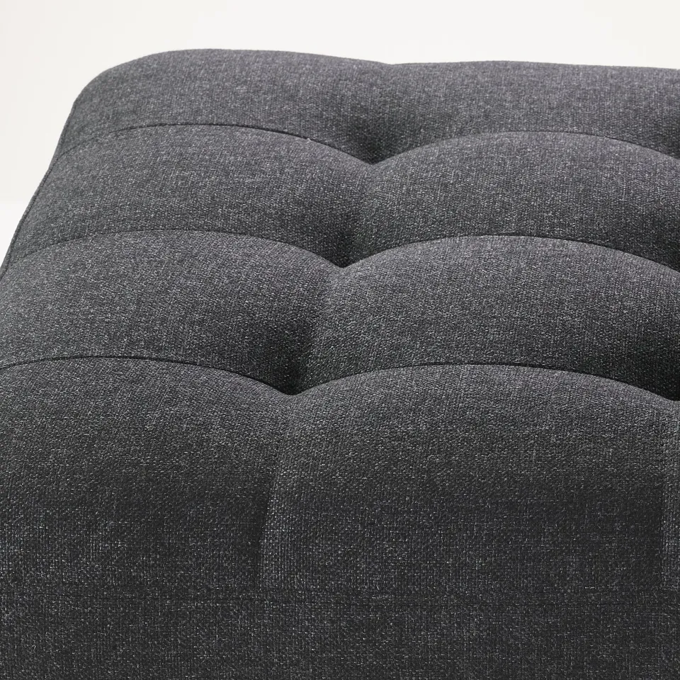 Grey, modern footstool with smooth, wave-like, tufted design, offering comfort and style.