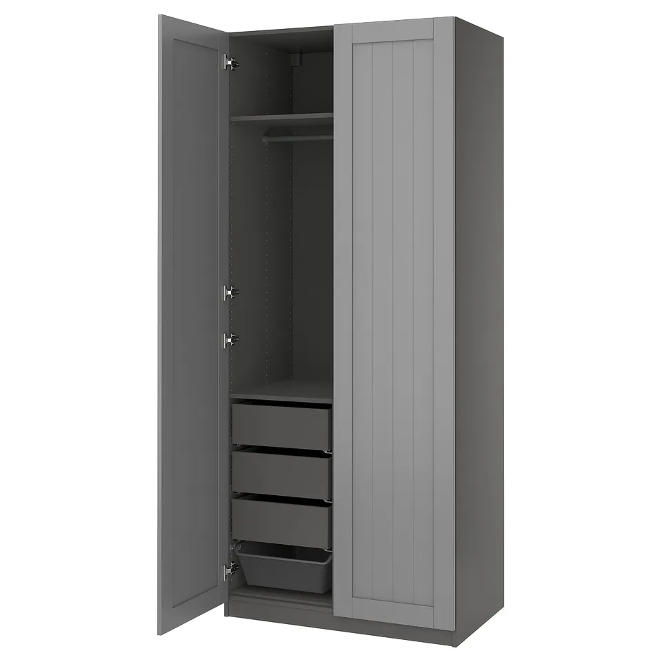 A grey PAX wardrobe with open doors revealing shelves and drawers. The modern design includes adjustable feet and soft-closing hinges.