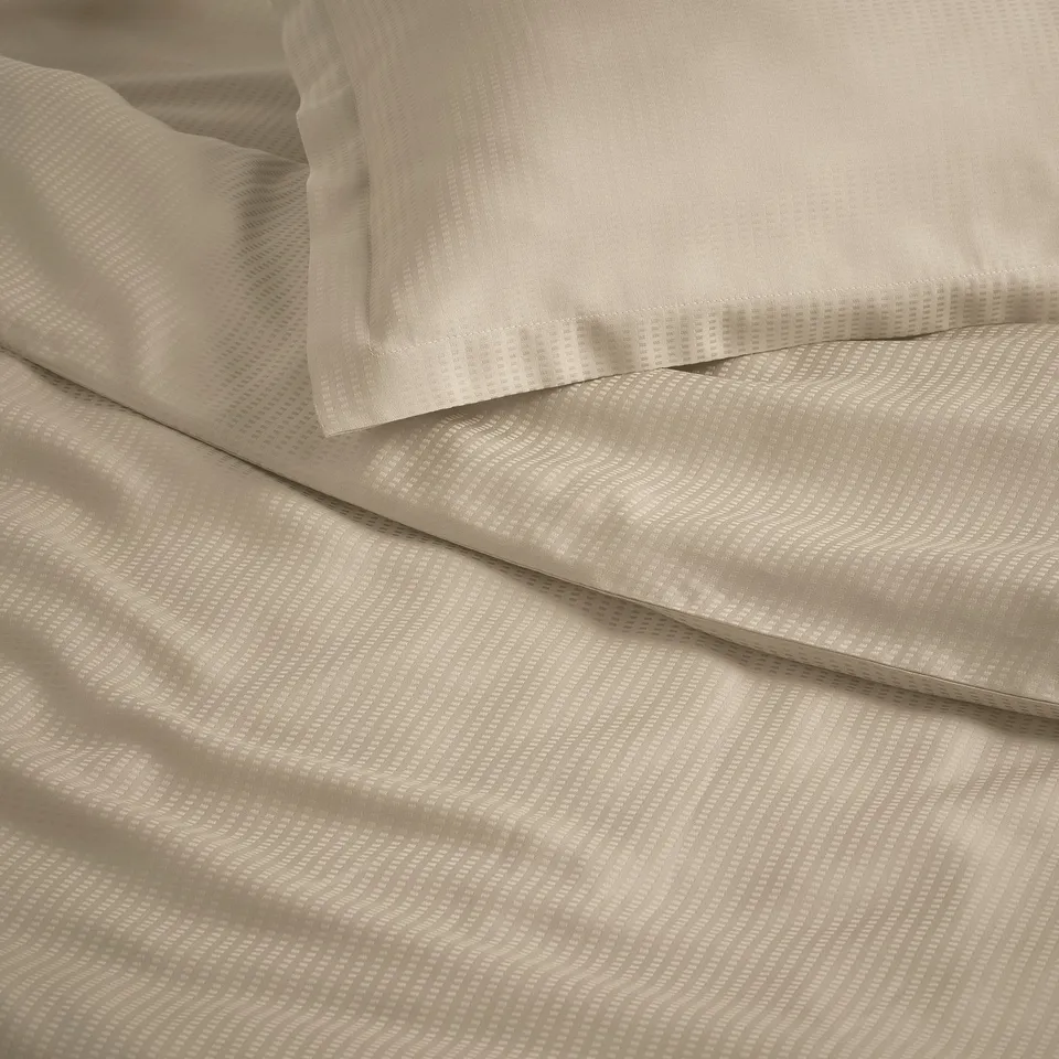 Elegant beige bedding set with subtle pattern, featuring smooth and soft fabric, perfect for warm nights.