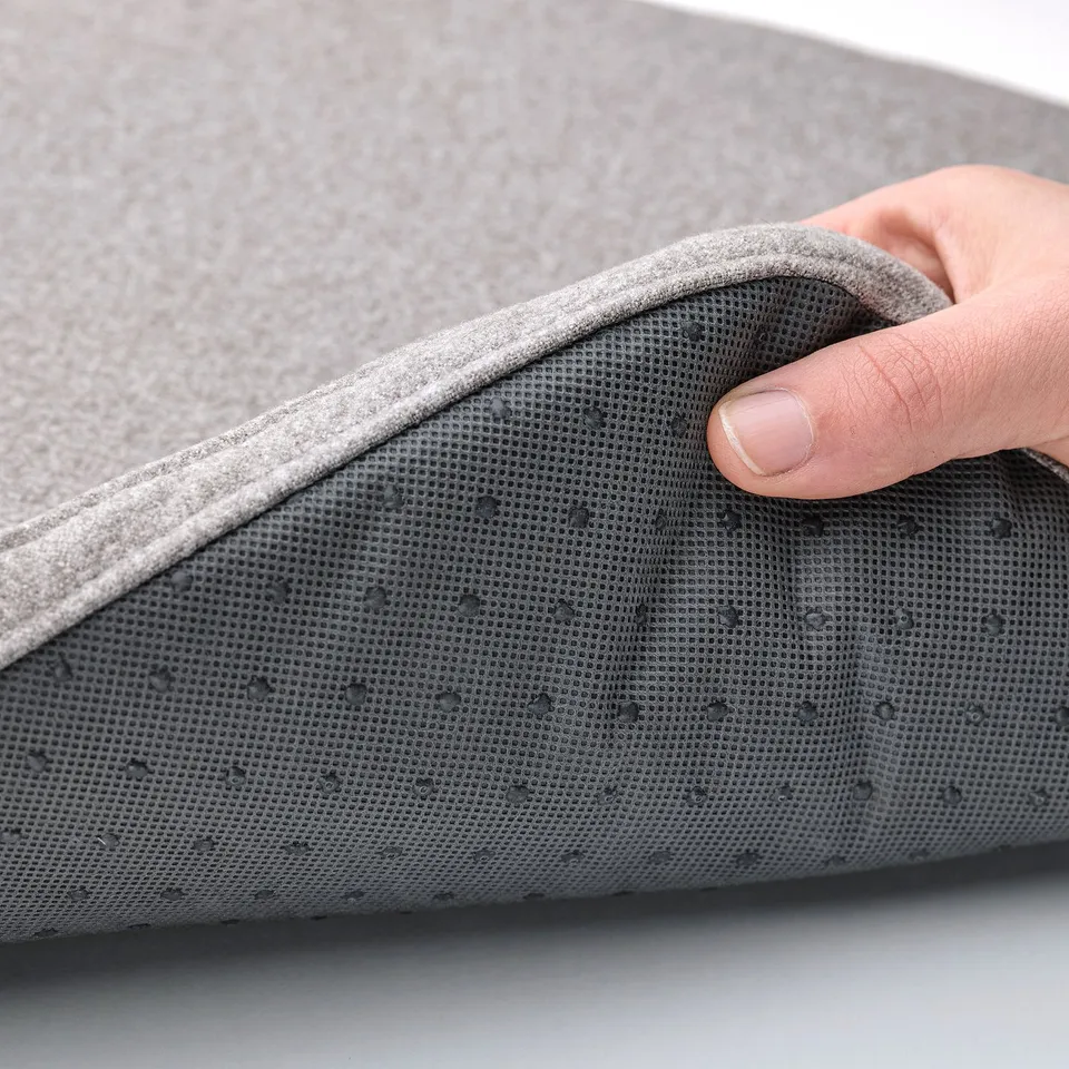 Person touching soft, grey chair pad with anti-slip dots on underside.