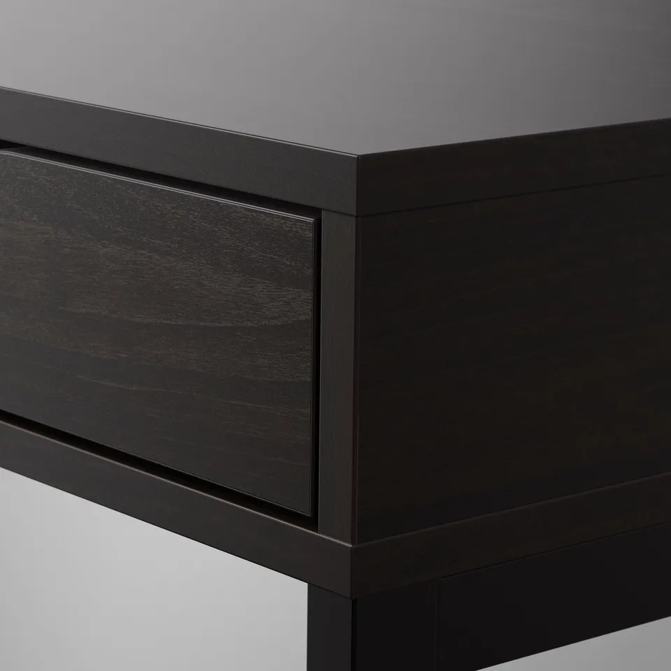 Close-up of sleek, modern black desk corner; smooth finish, sturdy design.