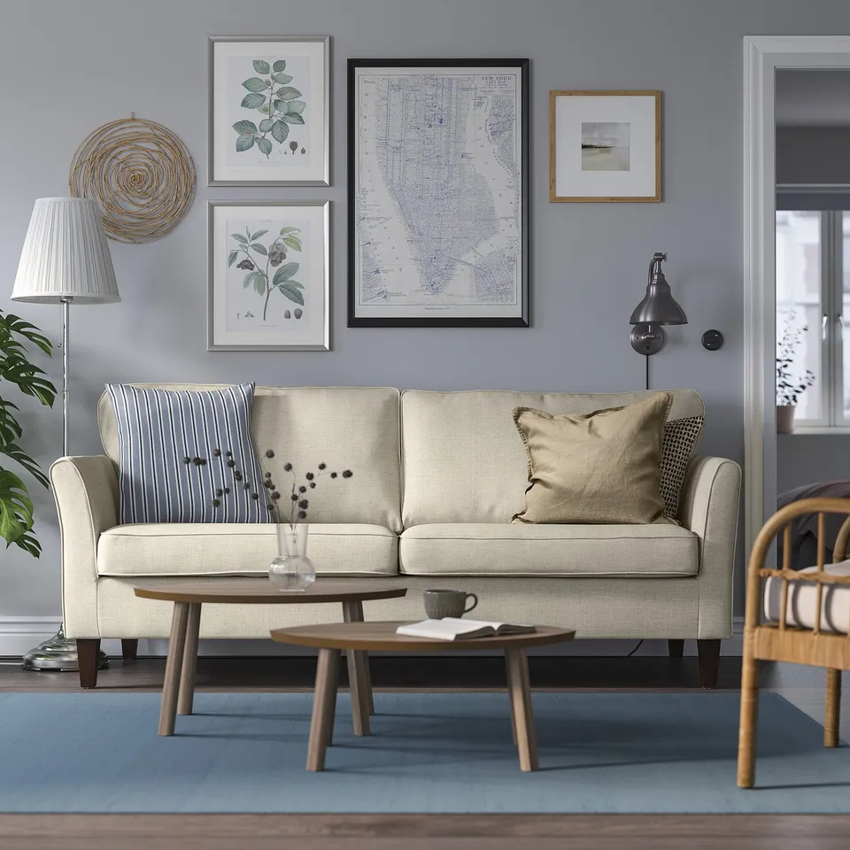 Beige 3-seat EKHOLMA sofa, removable covers, blue wall art, wooden coffee table, wicker chair, mid-century modern.